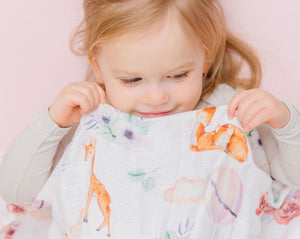 Baby girl in AquaLux Muslin Swaddle with locally designed print